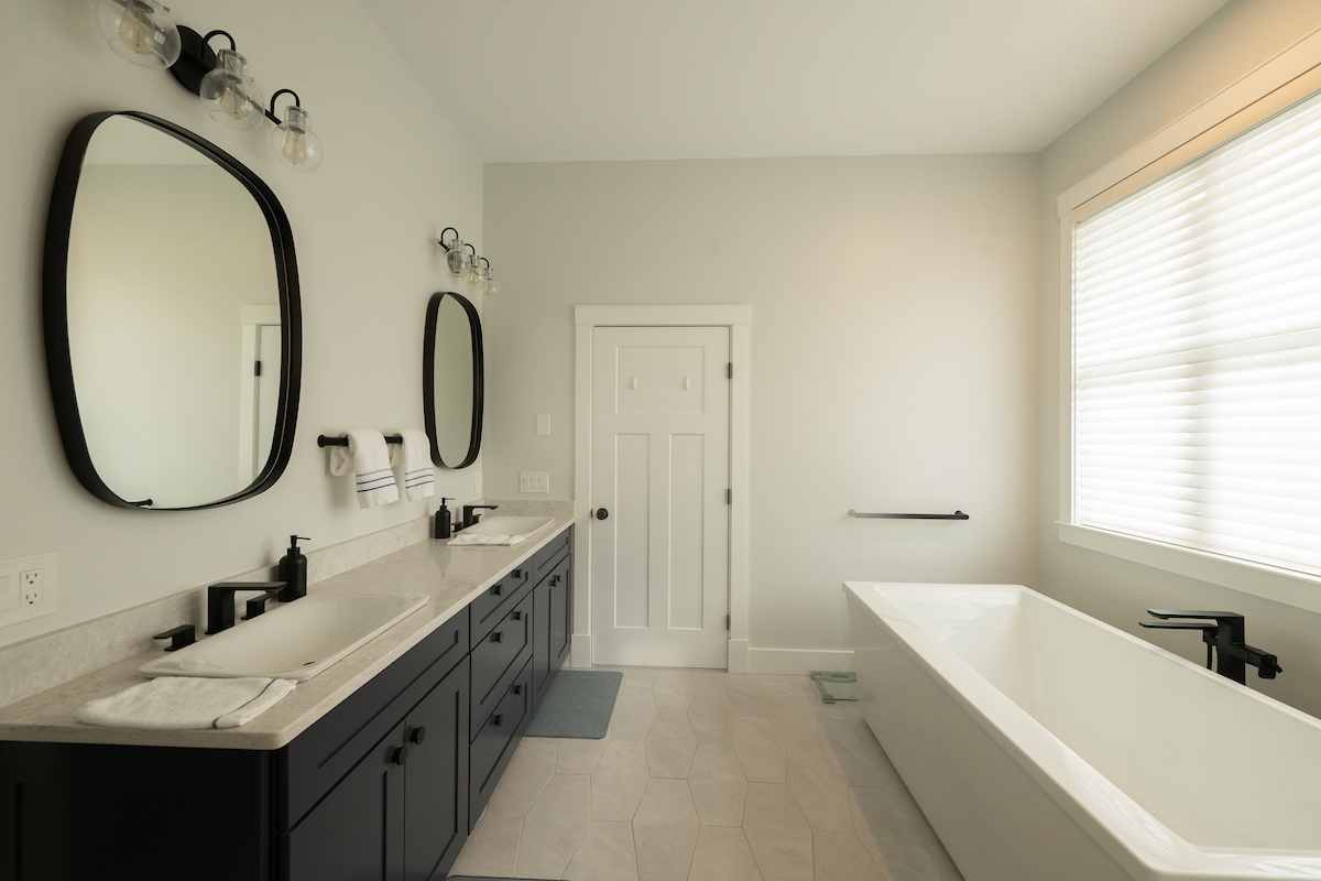Custom bathroom with double vanity and modern fixtures by Woodstone Homes in Dover NH