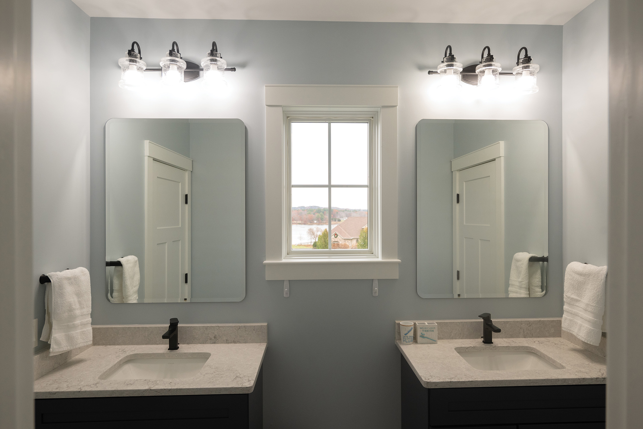 Double vanity bathroom with custom cabinetry and stone tops in Dover NH by Woodstone Homes